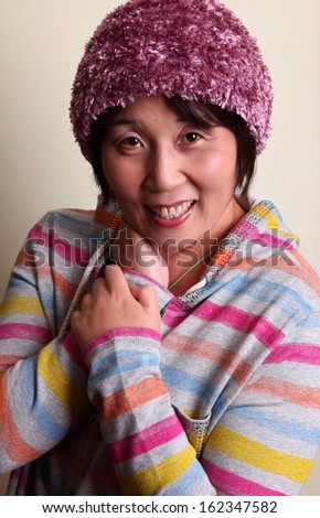 Japanese woman smiling/ Young at heart/ head and shoulders portrait of a middle aged Japanese woman in a colorful outfit