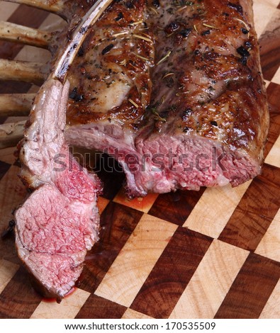 Tasty rack of lamb/Rack of lamb/A tasty rack of lamb straight out of the oven with one cutlet sliced.