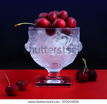 Fresh cherries on ice/Cherries on ice/Fresh juicy cherries on ice in a beautiful crystal bowl. Shot in studio.