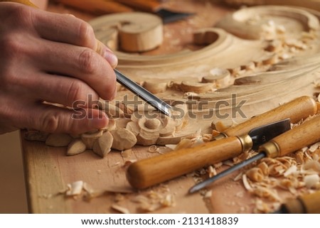 Wood carving. Carpenter's hands use chiesel. Senior wood carving professional during work. Man working with woodcarving instruments 商業照片 © 