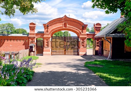 red brick fence and gates against the blue sky