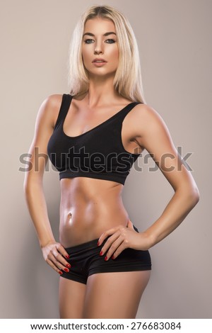 Sexy sporty woman with slim stomach over white background