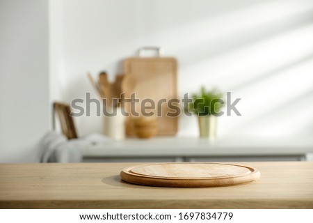 Table background of free space and kitchen interior.White wall with shadows and sunny warm morning time.Copy space for your composition. 