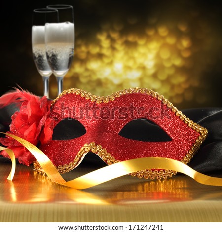 red mask and gold ribbon and champagne