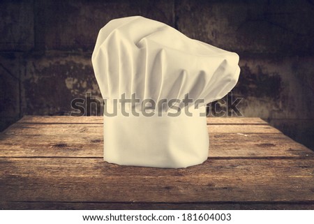 one single white cook hat and dark background of bar