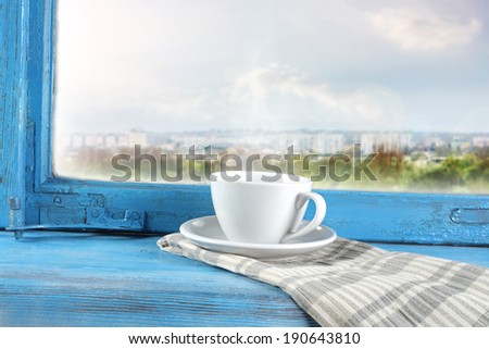 city and coffee cup on blue window