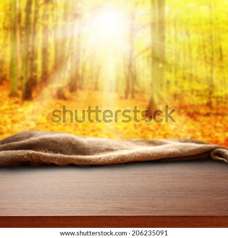 brown furniture desk with napkin and autumn sun in forest