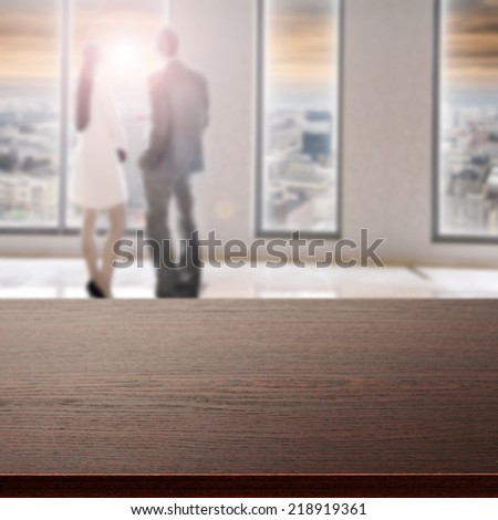dark desk window with city landscape and two people in sunset