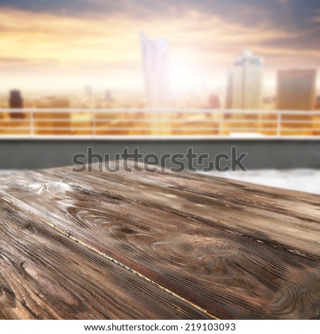 worn old table and city landscape of sunset
