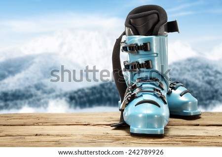 blue sport shoes of ski on desk of wood and sky of winter