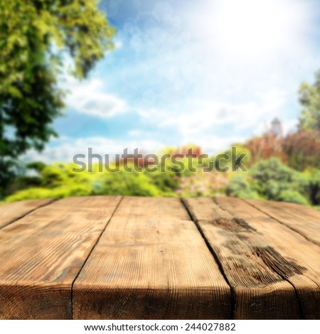 spring or summer background of garden and big worn old table in sunny day