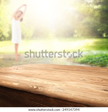 woman in spring garden at morning time and table of wood and free space
