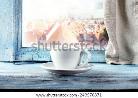 white mug of coffee and window of blue