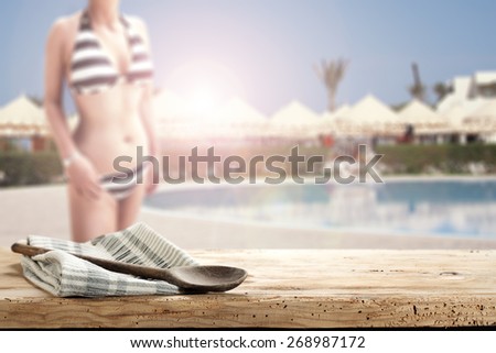 summer background of table with space for you and napkin spoon and woman in swimsuit