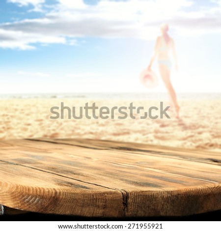 woman in bikini on hot summer sand of beach and wooden desk and free space for you
