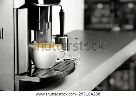 desk top of gray color coffee machine and warm coffee