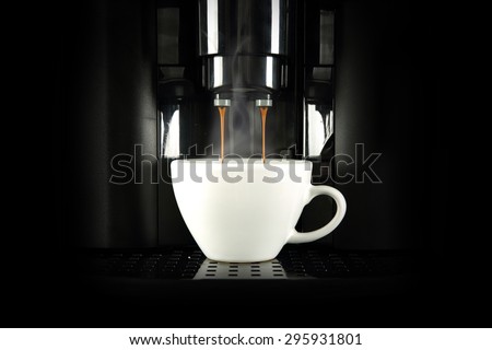 black coffee machine and white cup of coffee in dark space