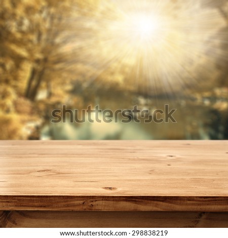 desk top of wood and blurred background of autumn space
