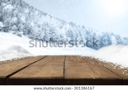 winter wooden table snow and trees of snow with blue sky with sun