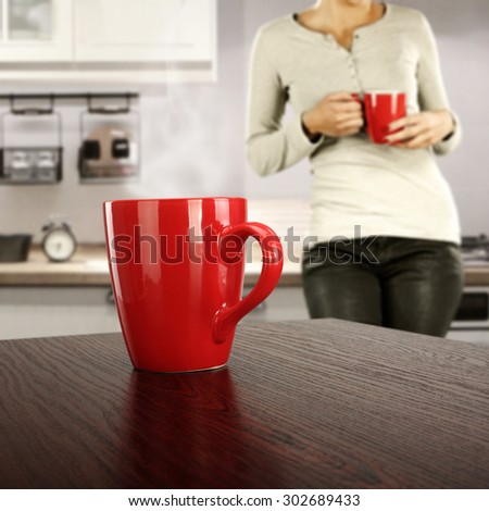 board of red color and red mug on top and woman in kitchen