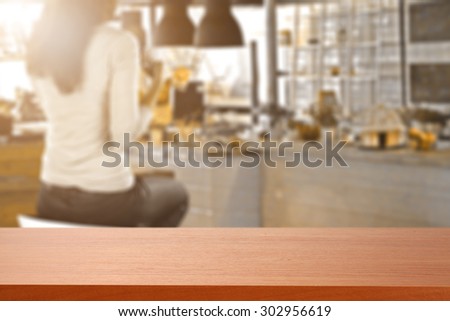 blurred background of bar with woman on chair and red cafe desk