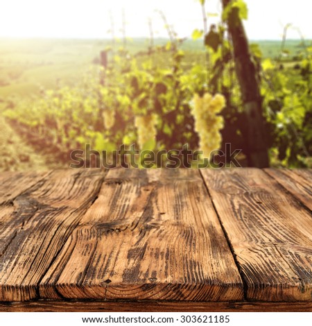 blurred background of vineyard and wine bottle place and summer sun