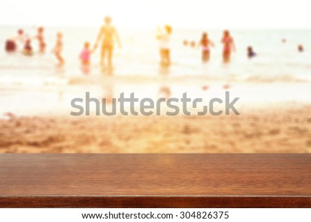 blurred background of people in water of sea and brown furniture top