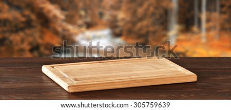 blurred background of autumn forest with river and kitchen desk