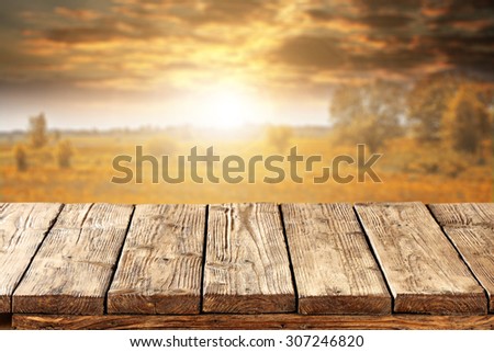 blurred background of autumn sunset and landscape with golden trees with table