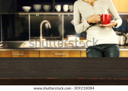 blurred background of kitchen and woman with red mug with dark board
