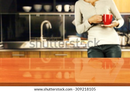 blurred background of kitchen and woman with red mug with red glasses board