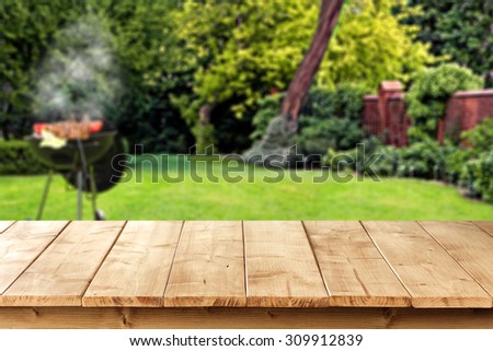 blurred background of green garden with grill time and wooden pier