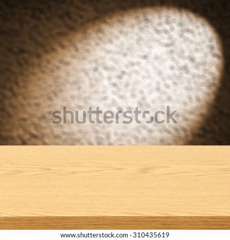 blurred brown background of wall with shadow of lamp and yellow wooden desk space and space for your decoration
