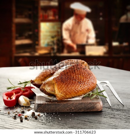 young cook in kitchen interior of bar and stone desk and meat of duck