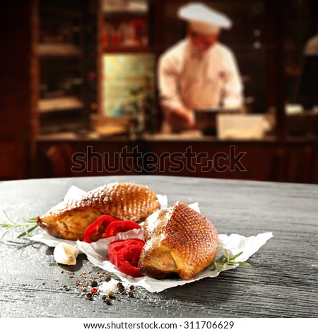 young cook in kitchen interior of bar and meat on paper