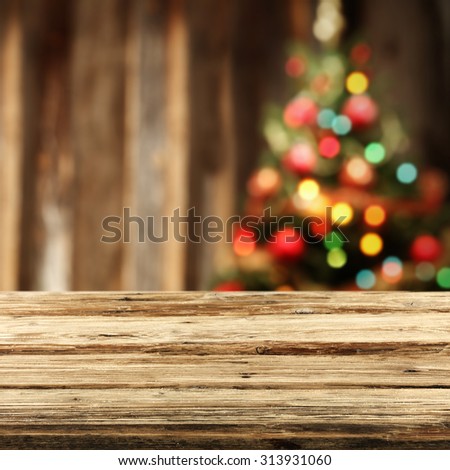 blurred background of xmas tree lights and wall with worn board place