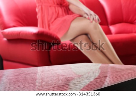 red sofa background with woman legs and space on top