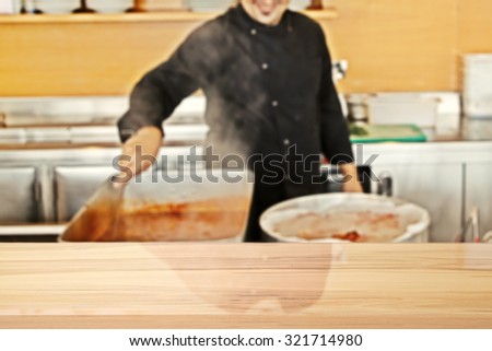 blurred background of cook and yellow wooden desk space in kitchen