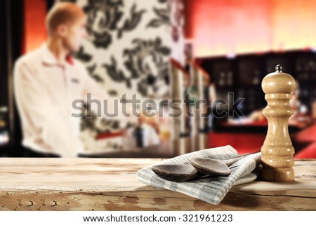 blurred background of bar and two wooden spoons napkin and desk top
