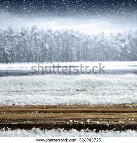 blurred background of winter and gray trees and desk and winter lake