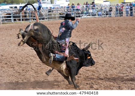 APACHE JUNCTION, AZ - FEBRUARY 27: A cowboy rides a bucking bull in the bull riding competition at the Lost Dutchman Days Rodeo on February 27, 2010 in Apache Junction, Arizona.