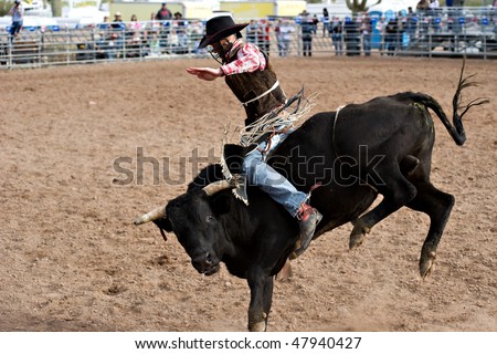APACHE JUNCTION, AZ - FEBRUARY 27: A cowboy rides a bucking bull in the bull riding competition at the Lost Dutchman Days Rodeo on February 27, 2010 in Apache Junction, Arizona.