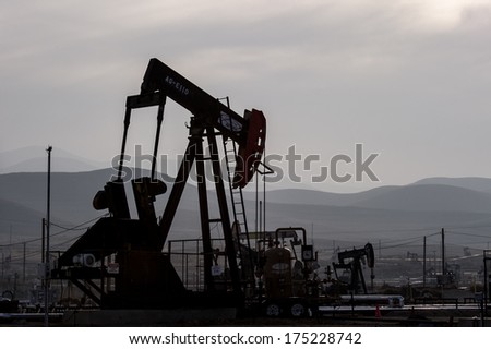 KERN COUNTY, CALIFORNIA - NOVEMBER 26, 2013: Pumpjacks extract oil from an oilfield in Kern County, CA. About 15 billion barrels of oil could be extracted using hydraulic fracturing in California.