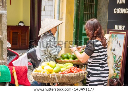 QUAND NAM, VIETNAM - MARCH 20 : Unidentify woman,Fruit seller, sell her fruit that carry on a bicycle on March 20,2013 at HoiAn city Quand Nam,Vietnam.