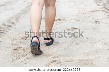 human legs walking on the beach