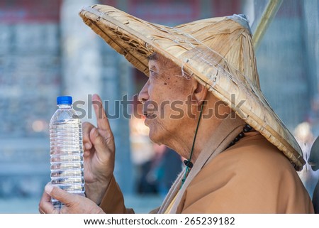 SUN MOON LAKE, TAIWAN - NOVEMBER 30: An old Taiwanese monk at the Wenwu temple is blessing a bottle of water on November 30, 2010 in Sun Moon Lake.