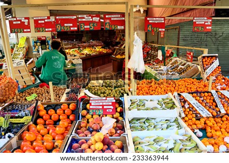 PARIS, FRANCE - OCTOBER 18 : Market fruit stall at Mouffetard street in Paris with fruits for sale on the foreground and vendor on the background on October 18th, 2013