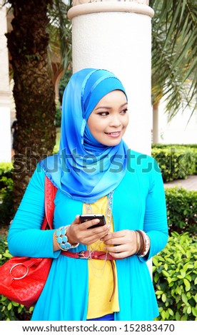 Pretty hijab woman with handphone