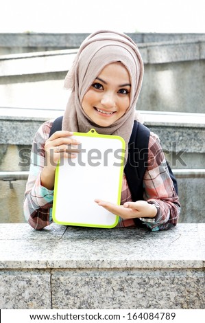 Portrait of a beautiful Muslim woman holding a white board