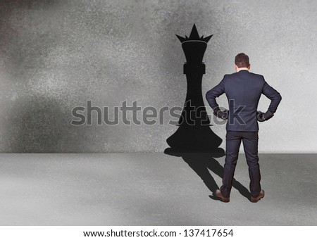 businessman with chess king shadow for street
